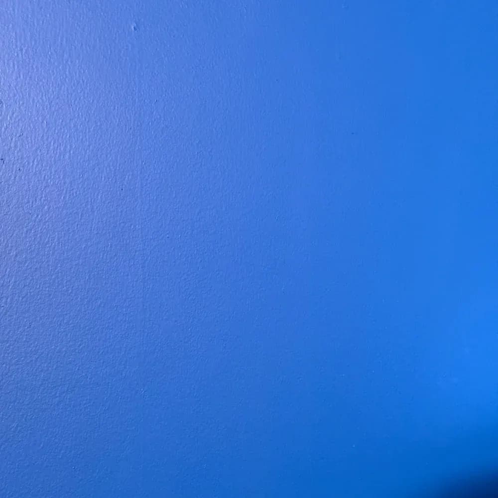 A blank blue textured wall in a home bar area before being decorated with a custom LED beer lodge man cave sign.